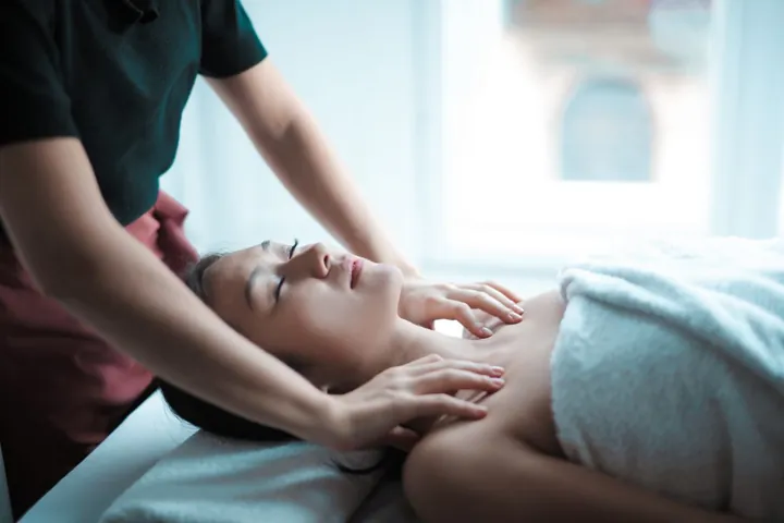 A professional providing a neck and shoulder massage in a spa